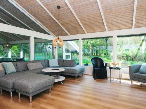 a living room with a couch and chairs and windows at 4 star holiday home in Bindslev in Bindslev