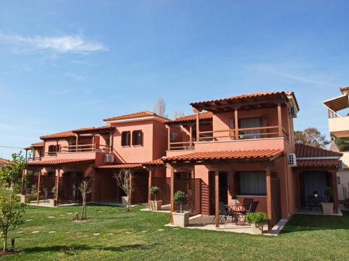 a large pink house with a green yard at Melograno Apartments and Studios in Kala Nera