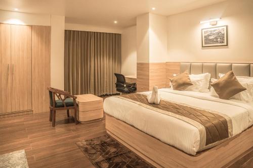a hotel room with a bed and a desk at Hotel Arjay Valley, Pure Veg Luxury Hotel in Darjeeling