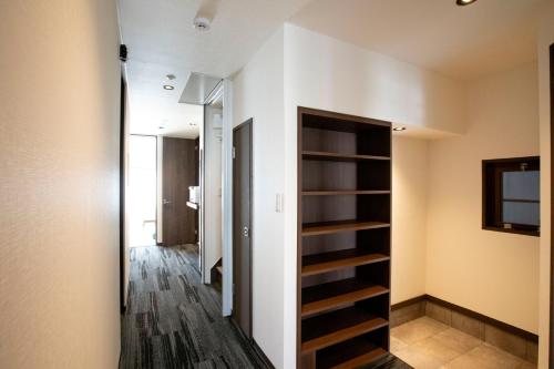 a room with a hallway with a book shelf at RouTe5 in Matsumoto