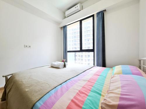 a bedroom with a rainbow bed and a window at Apt SKY house 2br cozy & family in Cisauk 1