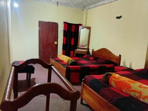 a living room with two beds and a mirror at Silonya Forest Edge in Nuwara Eliya