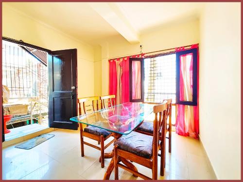 a dining room with a glass table and chairs at HOTEL You & Me Near Mall Road & NAINI LAKE - Free Wifi & Room Service With Parking Facilities - Hygiene and Spacious Room - The Best Hotel with Mountain Views - Best Hotel In Nainital in Nainital