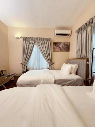 a hotel room with two beds and a window at Hayat Apartments & Homes in Lagos