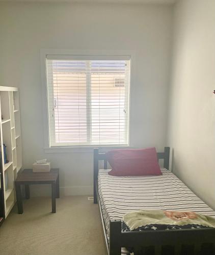 ein kleines Schlafzimmer mit einem Bett und einem Fenster in der Unterkunft Lily Rentals in Langley