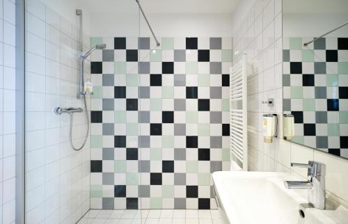 a bathroom with a black and white checkered wall at Im-Jaich Hotel Bremerhaven in Bremerhaven
