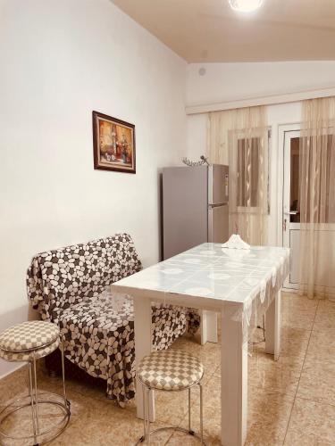 a white table and chairs in a kitchen with a refrigerator at House - Kutaisi International Airport 15 Minutes, Samtredia Kulashi 15Tamar Mepe Street in Samtredia