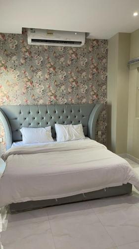 a bedroom with a large bed with a floral wall at فيلا السعادة بيتش درة العروس رملي وخاص in Durat  Alarous