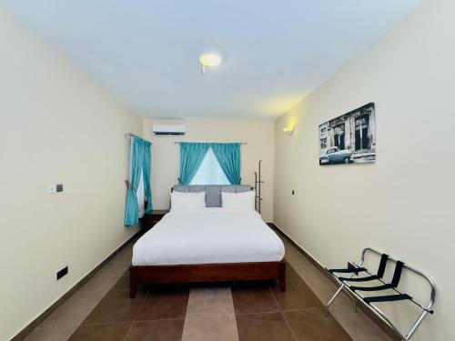 a bedroom with a bed and blue curtains at Hayat Apartments & Homes in Lagos
