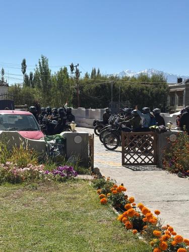 a bunch of motorcycles parked next to a bunch of flowers at Mandalchan hotel in Leh