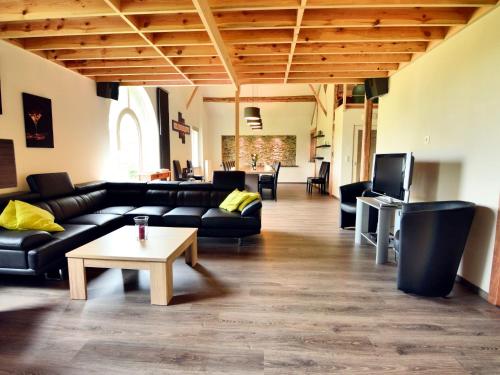 a living room with black couches and a coffee table at Spacious Villa with Charm in Bertogne