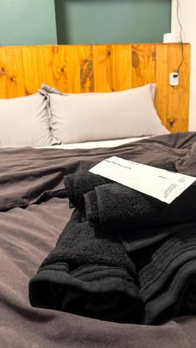 a bed with a piece of paper on top of it at Pa-Hinga Kaliwa Homey Japandi Studio Retreat in Baler