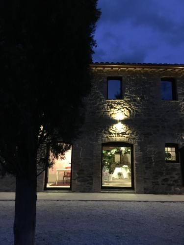 a stone building with a tree in front of it at Agriturismo Fonte Rosa in Fiastra