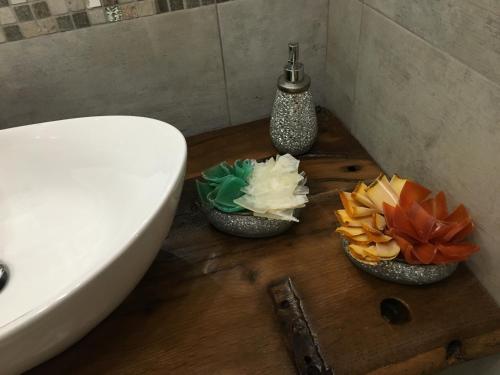 a bathroom with three bowls of soap and a sink at Agriturismo Fonte Rosa in Fiastra