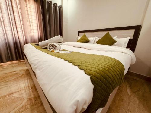 a bedroom with two beds with green and white sheets at Hotel Krishna Residency - Top Rated !! Most Awarded !! Lift !! Family Friendly !! Budget Friendly in Vrindāvan