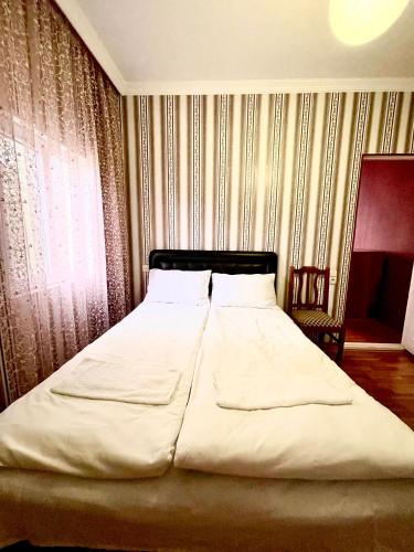 a bedroom with a large white bed in front of a window at House - Kutaisi International Airport 15 Minutes, Samtredia Kulashi 15Tamar Mepe Street in Samtredia