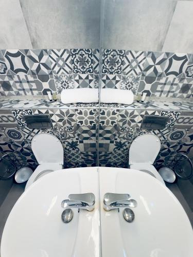 a bathroom with a white sink and a tile wall at Hayat Apartments & Homes in Lagos