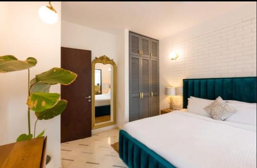 una camera da letto con un letto bianco e uno specchio di Vagator Royale 2BR Villa Near Vagator, Goa ad Assagao