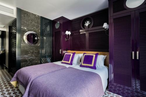 a purple bedroom with a bed with two purple pillows at Room Mate Anna, Barcelona in Barcelona