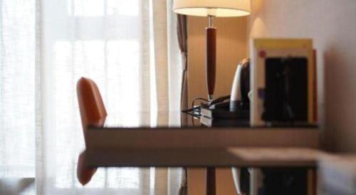 a desk with a chair next to a window at Hefei Parkview Hotel in Hefei