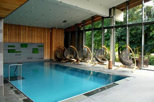 a swimming pool in a building with windows at Konsum Berghotel Oberhof in Oberhof