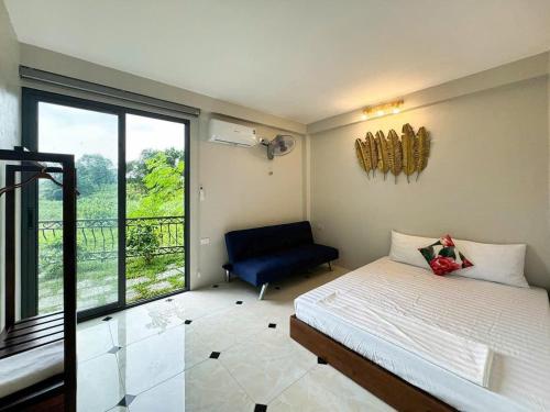 a bedroom with a bed and a chair and a window at Le Soleil Ba Vì in Ba Vì