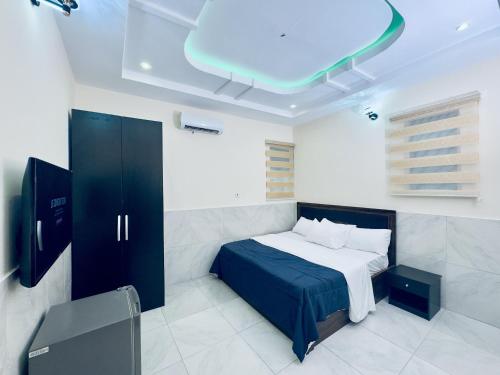 a bedroom with a bed and a blue ceiling at Hayat Apartments & Homes in Lagos