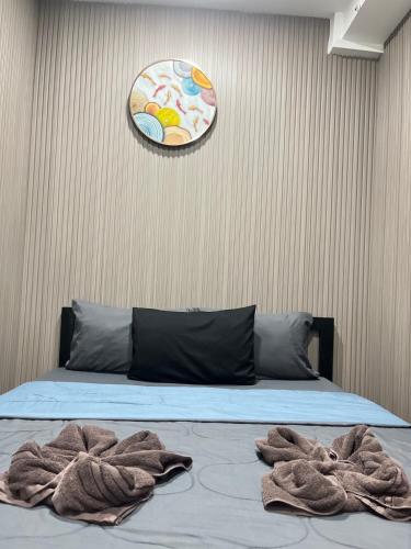 a bedroom with a bed with towels on it at DonMueang station hotel in Ban Don Muang