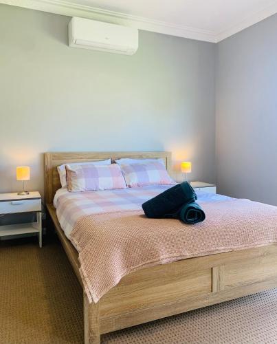 a bedroom with a large bed with two lamps at Rose Garden Retreat in Timboon