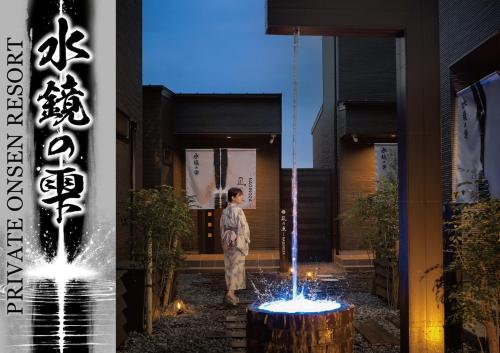 a person standing in front of a building with a fountain at Villa 水鏡の雫 in Beppu