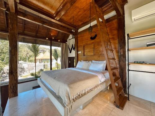 Un dormitorio con una cama y una ventana grande. en Ocean Bay Retreat, en Bingin Beach