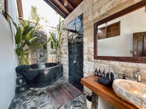 Un baño con una bañera grande y un lavabo. en Ocean Bay Retreat, en Bingin Beach