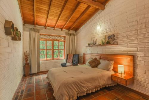 Un dormitorio con una cama grande y una ventana. en Provenza Garden House-Villa-4BR, en Medellín