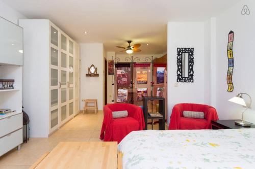 1 dormitorio con 2 sillas rojas y 1 cama en Apartamento La Higuera, en La Laguna