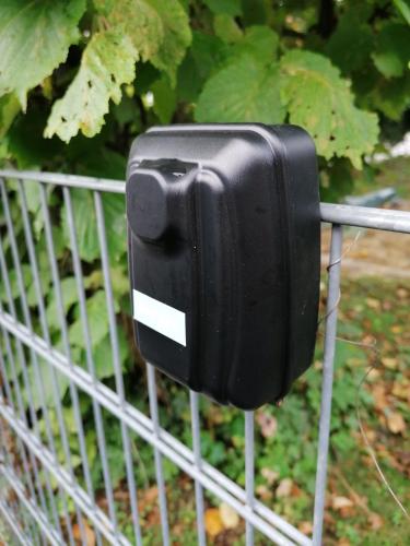 a black phone is attached to a fence at Appartement Borger in Sauerlach