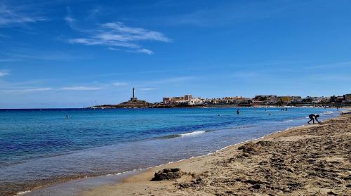 a group of people walking on the beach at Cabo de Palos Apartment in Cabo de Palos