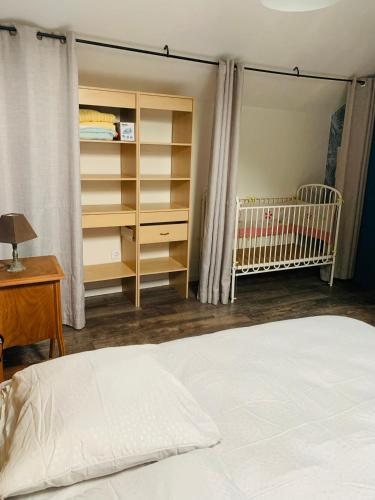 a bedroom with a bed and a crib and shelves at Gite la maison du pêcheur in Commes