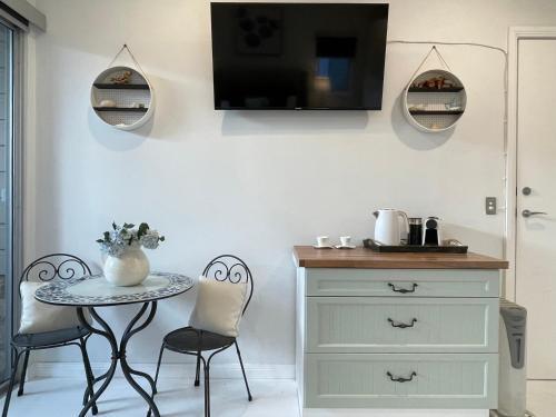 a dining room with a table and chairs and a tv at Coral Cove in Narrabeen