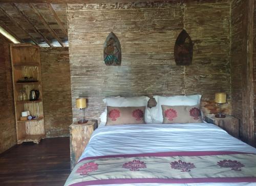 a bedroom with a bed in a wooden wall at DWan Tea Mountain Side in Jatiluwih