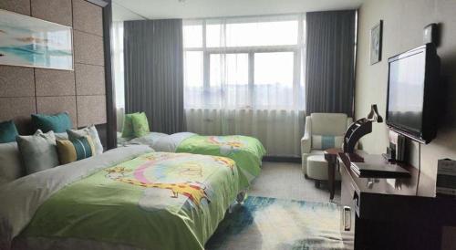 a bedroom with a bed and a flat screen tv at Huangshan International Hotel in Huangshan