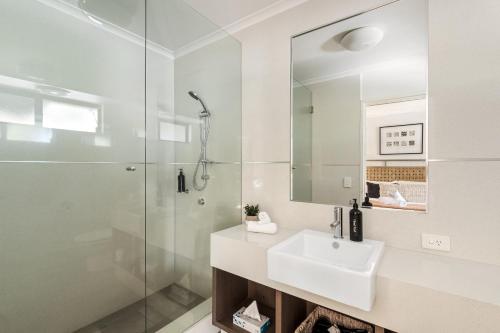Un baño blanco con lavabo y ducha en Apartment 46, en Margaret River Town
