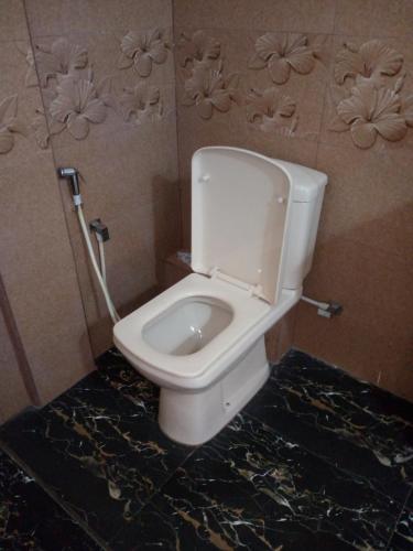 a bathroom with a white toilet in a room at Birdsong Guest House in Ambalangoda