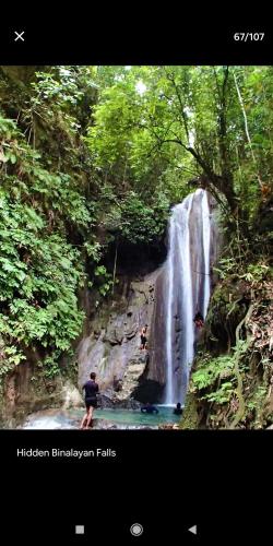 a man standing in front of a waterfall at Beach House at Carolina del Mar in Samboan