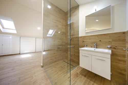 a bathroom with a glass shower and a sink at Idassa Atrium rooms in Zadar