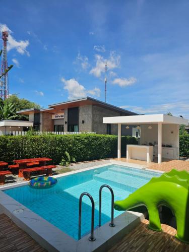 a swimming pool with a pool noodle in front of a house at Vamin Poolvilla Chiangkhan Loei วามินทร์พูลวิลล่า เชียงคาน เลย - วามินทร์ รีสอร์ท in Chiang Khan