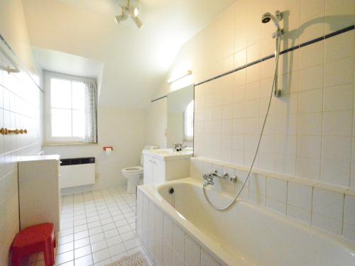 a bathroom with a tub and a toilet and a sink at Spacious villa near Lesse in Daverdisse