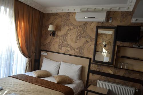 a bedroom with a bed with a mirror and a wall at Ares Hotel in Istanbul