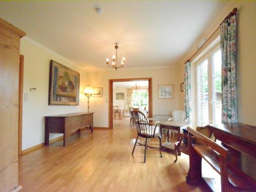a living room with a table and a piano at Spacious villa near Lesse in Daverdisse