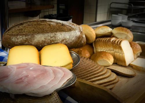 a bunch of different types of bread and cheese at Hotel De Oude Brouwerij in Mechelen