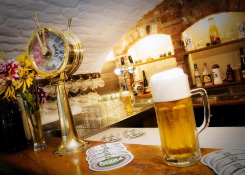 a glass of beer sitting on a counter with a clock at Hotel De Oude Brouwerij in Mechelen